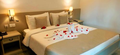 a hotel room with a bed with flowers on it at Le Relax Beach Resort in Grand'Anse Praslin