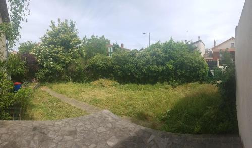 a view of a yard with grass and trees at Le Pierre CURIE Chez l'habitant in Pierrefitte-sur-Seine