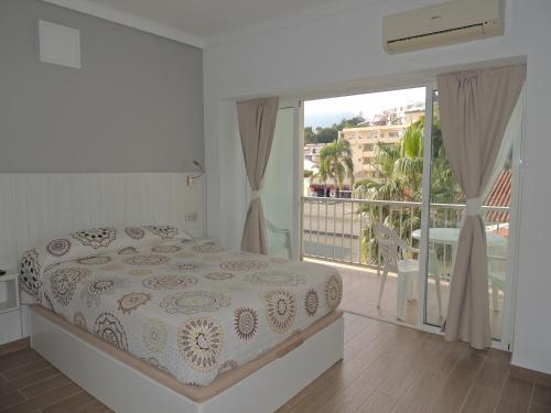 ein weißes Schlafzimmer mit einem Bett und einem Balkon in der Unterkunft Carihuela Palace Studio 418 Beach - Playa in Torremolinos
