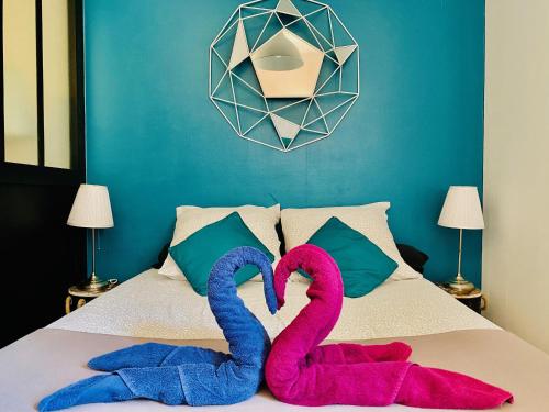 2 serviettes roses et bleues assises sur un lit dans l'établissement MAGNIFIQUE T2 NEUF TOP EMPLACEMENT !, à Sète