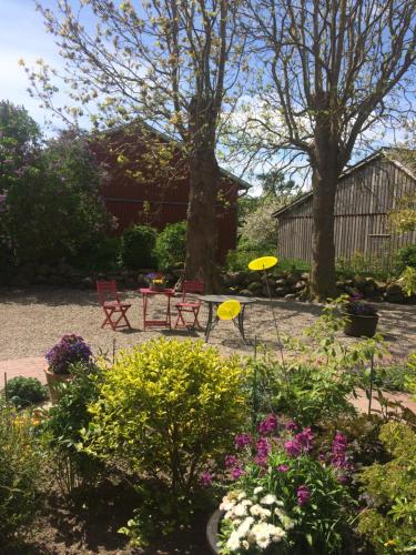 a garden with a table and chairs and flowers at Gästehaus Muhl in Strukkamp auf Fehmarn