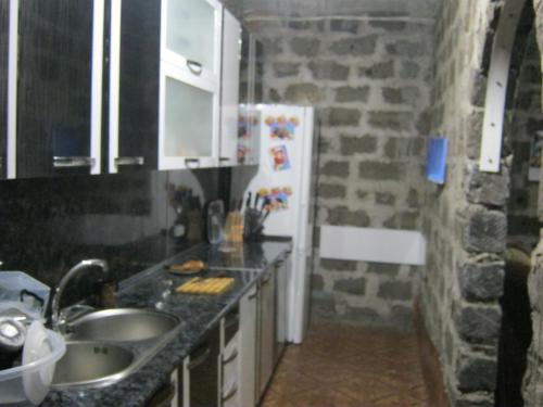 AshtarakにあるVacation Home in Ashtarakの石壁のキッチン(白い冷蔵庫付)
