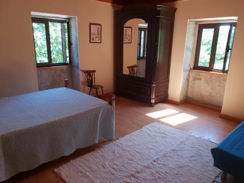 a bedroom with a bed and two windows at Casa Do Fiscal in Barroselas