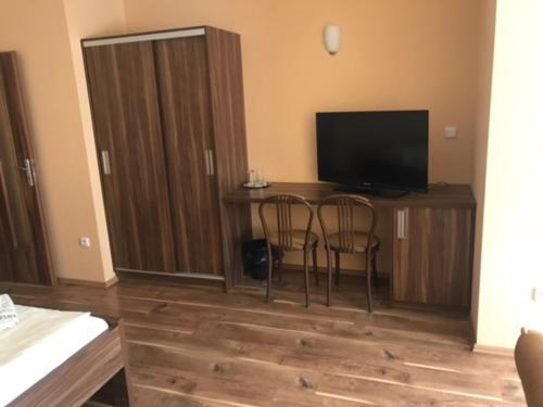 Habitación con mesa con 2 sillas y TV. en Bezměrovský dvůr Kroměříž en Kroměříž