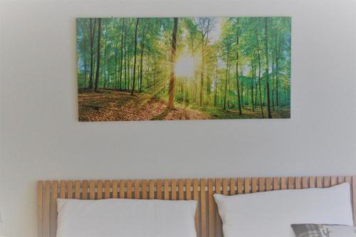a painting of a forest above a bed at Ferienwohnung Ströbele in Müllheim