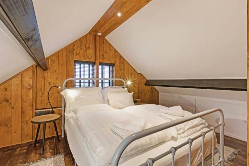 a hospital bed in a room with wooden walls at Uniek houten huis nabij bos en plassen in Hollandsche Rading