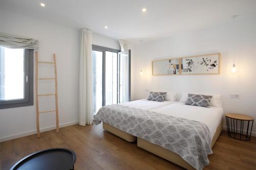 biała sypialnia z łóżkiem i drabiną w obiekcie Petit Artà w mieście Artá