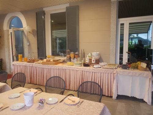 a long table with tables and chairs with food on it at Hotel Due Palme in Mergozzo