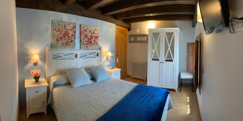 a bedroom with a large bed with a blue blanket at Villa Fontanas in Hontanas