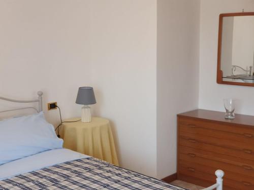 Schlafzimmer mit einem Bett, einer Kommode und einem Spiegel in der Unterkunft Stanza Angiolina in Forte dei Marmi