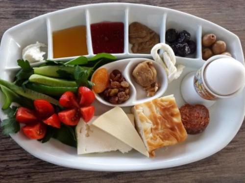 a plate of food with cheese and fruits and vegetables at Nar Palace in Istanbul