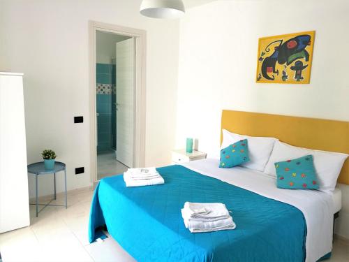 um quarto com uma cama azul com toalhas em Mimama em Telese Terme