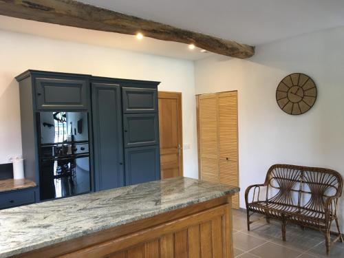 une cuisine avec un comptoir, une table et des chaises dans l'établissement Gîte Petitou, à Jasses