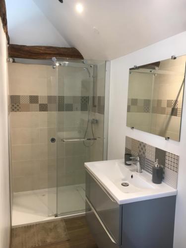 une salle de bain avec un lavabo et une douche dans l'établissement Gîte Petitou, à Jasses