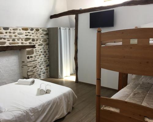 une chambre avec un lit et un lit superposé dans l'établissement Gîte Petitou, à Jasses