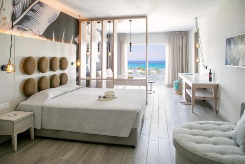 a bedroom with a bed and a table and a desk at Vangelis Hotel & Suites in Protaras