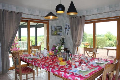 a dining room with a table with a red table cloth at Chambre D'hotes Le Clos Fleuri in Criel-sur-Mer