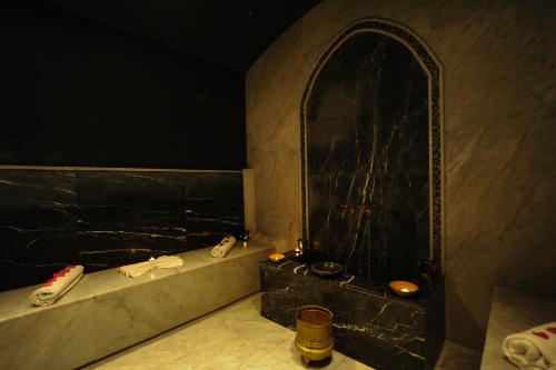 a bathroom with a bath tub with a black wall at Radisson Blu Resort Taghazout Bay Surf Village in Taghazout
