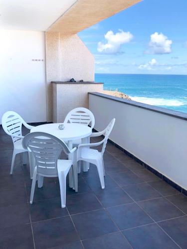 a table and chairs on a balcony with the ocean at Cotillo Ocean View in Cotillo