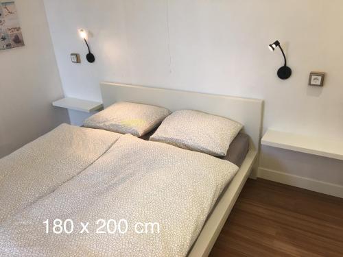 um quarto com uma cama com duas almofadas em Annadora Beach House - Free Parking em Zandvoort