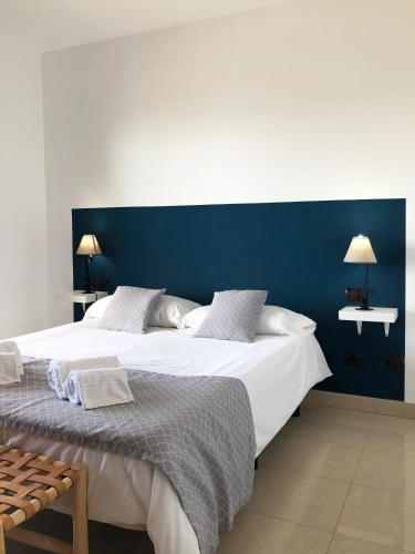 a bedroom with a large bed with a blue wall at Cotillo Ocean View in Cotillo