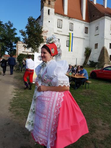 a young girl in a dress standing in front of a castle at Ubytování nad sklípkem in Valtice