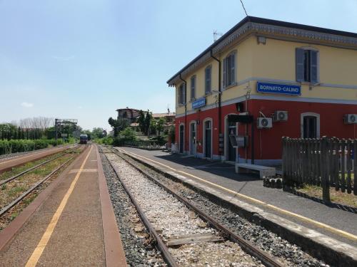 a train station with a train on the tracks at Franciacorta flat & bollicine in Passirano