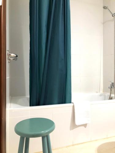 a stool in a bathroom with a blue shower curtain at Cotillo Ocean View in Cotillo