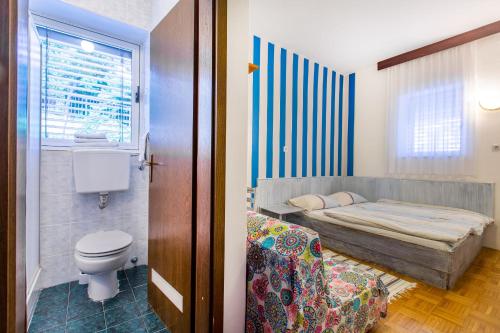 a bedroom with a bed and a toilet and a window at Maestral Residence in Portorož