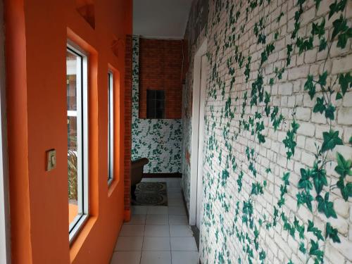 a hallway with an orange door and a brick wall at Pemda 22 Mansion Mitra RedDoorz in Bogor