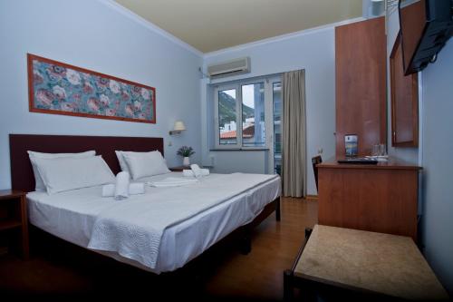 A bed or beds in a room at Grand Hotel Loutraki