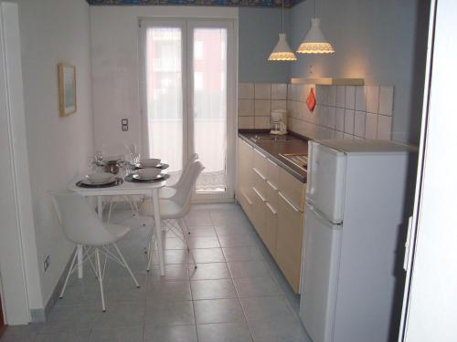 a kitchen with a table and a white refrigerator at Apartman Roman Mandre in Mandre