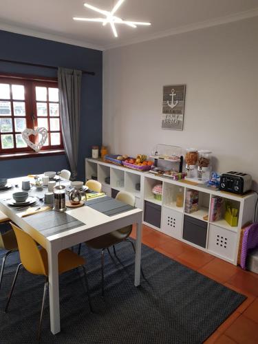 エスモリスにあるBeachwalk guesthouseのダイニングルーム(白いテーブル、黄色の椅子付)