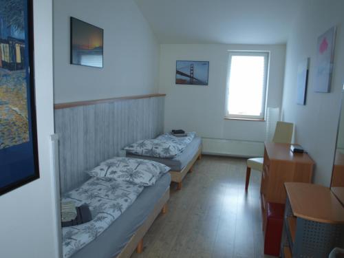Habitación pequeña con escritorio y 2 camas en BAILANDO Studio, en Neratovice