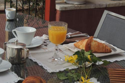 a table with a glass of orange juice and bread at Sous L'Olivier in Menton