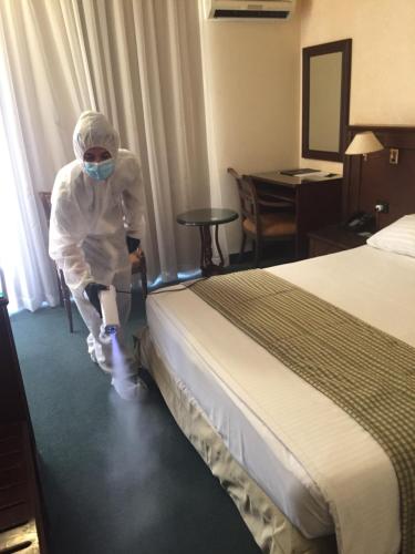 a person in a hotel room with a bed at The Mayflower Hotel in Beirut