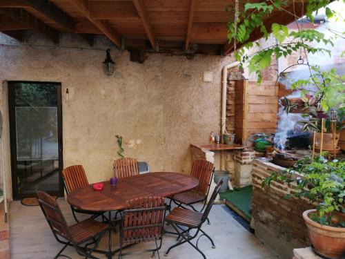 Une table et des chaises en bois sont disponibles sur la terrasse. dans l'établissement Gîte bord du Tarn, à Gaillac