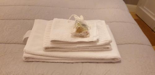 een stapel handdoeken bovenop een bed bij La Piazza in Cantalupo in Sabina