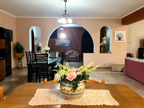 a dining room and living room with a vase of flowers on a table at Villa Zagara in Gioiosa Ionica