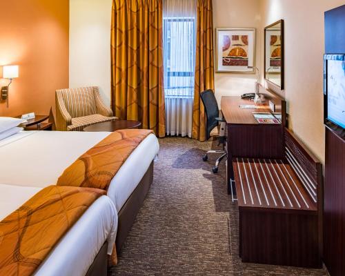 Habitación de hotel con 2 camas y escritorio en City Lodge Hotel Hatfield, Pretoria, en Pretoria