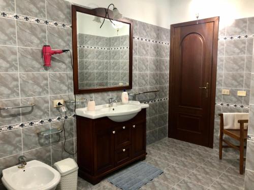 ein Badezimmer mit einem Waschbecken, einem Spiegel und einem WC in der Unterkunft Villa Zagara in Gioiosa Ionica