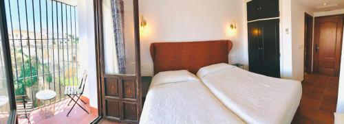a bedroom with a bed and a balcony at Hotel Don Miguel in Ronda