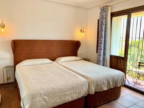 a bedroom with a large bed and a window at Hotel Don Miguel in Ronda