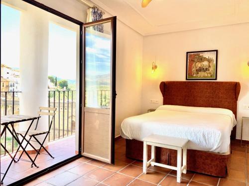 a bedroom with a bed and a balcony at Hotel Don Miguel in Ronda