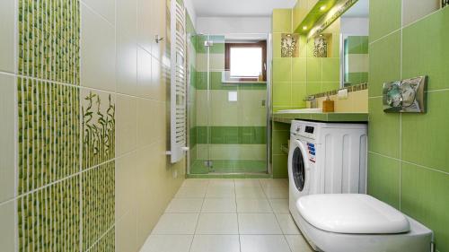a green bathroom with a washing machine in it at Aquarius Sopot - BillBerry Apartments in Sopot