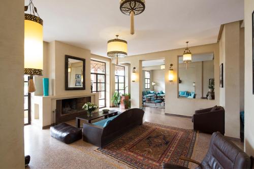 Douar TounsiにあるEcolodge Quaryati Marrakechのソファと暖炉のあるリビングルーム