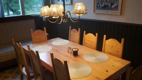 a wooden table with chairs and a wooden table with two lights at Rytterne Kyrkskola in Sorby