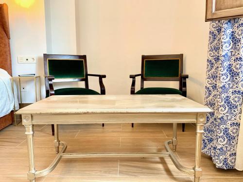 a table and two chairs in a room at Hotel Don Miguel in Ronda