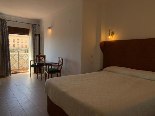 a hotel room with a bed and a table and chairs at Hotel Don Miguel in Ronda