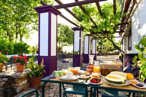 una mesa al aire libre con comida y fruta. en Quinta da Dourada, en Portalegre